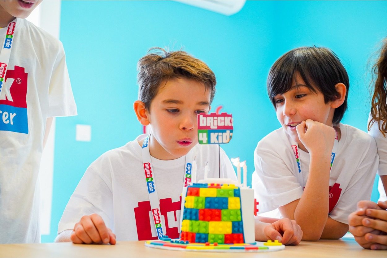 Deux enfants en t-shirt Bricks 4 Kidz concentrés sur leur construction